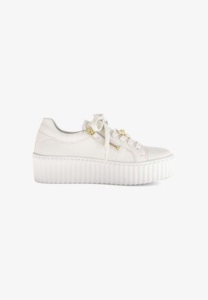 White platform sneaker with scalloped detail, gold zipper, lace-up front, and decorative charm on a plain white background.