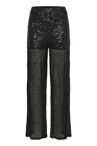 Pantaloni neri a gamba larga con un design a strati; la parte superiore presenta paillettes, mentre la parte inferiore è realizzata in pizzo trasparente con una texture decorata.