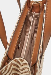 Braune Lederhandtasche mit gewebten beige und cremefarbenen gestreiften Akzenten. Das Innere verfügt über eine zippered Tasche und zwei Fächer, ausgekleidet mit beiger Baumwolle.