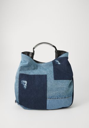 Denim tote taske med lapper i forskellige nuancer af blå, med en sort læderkant og et rundt sølvhåndtag. Tekstureret overflade.