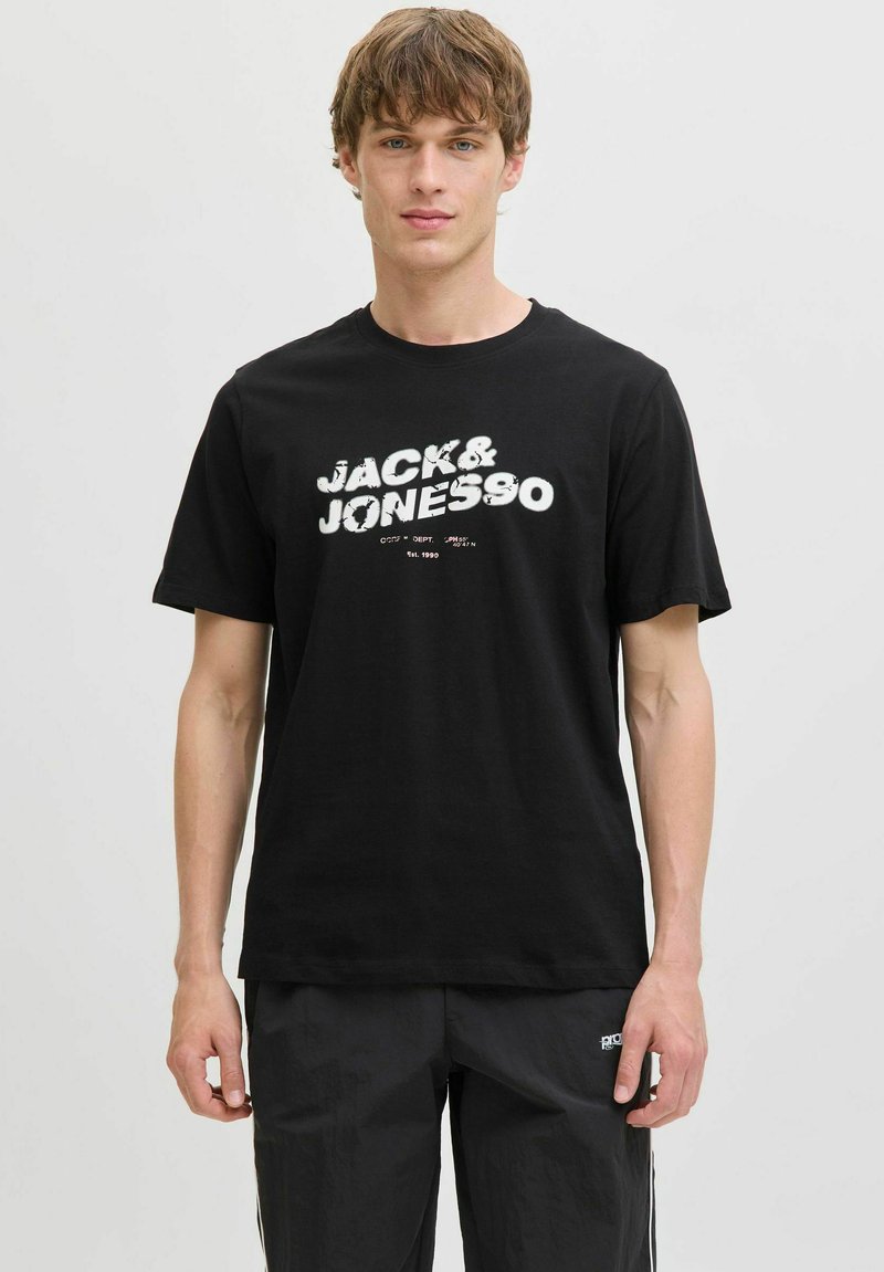 Sort bomulds T-shirt med hvid grafiktryk "JACK & JONES" på forsiden. Rund hals og korte ærmer, afslappet pasform.