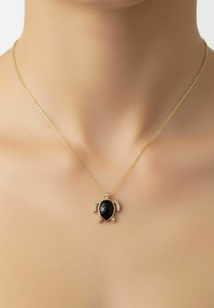 Gold chain necklace with turtle-shaped pendant featuring a black center stone and small clear gemstones on limbs and head.