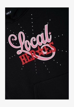 Schwarzer Hoodie mit "Local Heroes" in pinker und roter Schrift, verziert mit kleinen silbernen Nieten, ausgestattet mit einer Fronttasche und einer Kapuze mit Kordelzug.