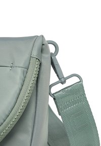 Zelená nylonová taška s texturovaným povrchem, vybavená zipem a kovovými sponami. Popruh zahrnuje tkané akcenty a pevné švy.