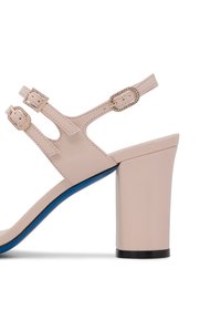 Sandal con tacco aperto beige, con due cinturini regolabili con fibbie, decorata con piccole cristalli e un accento blu sulla suola.