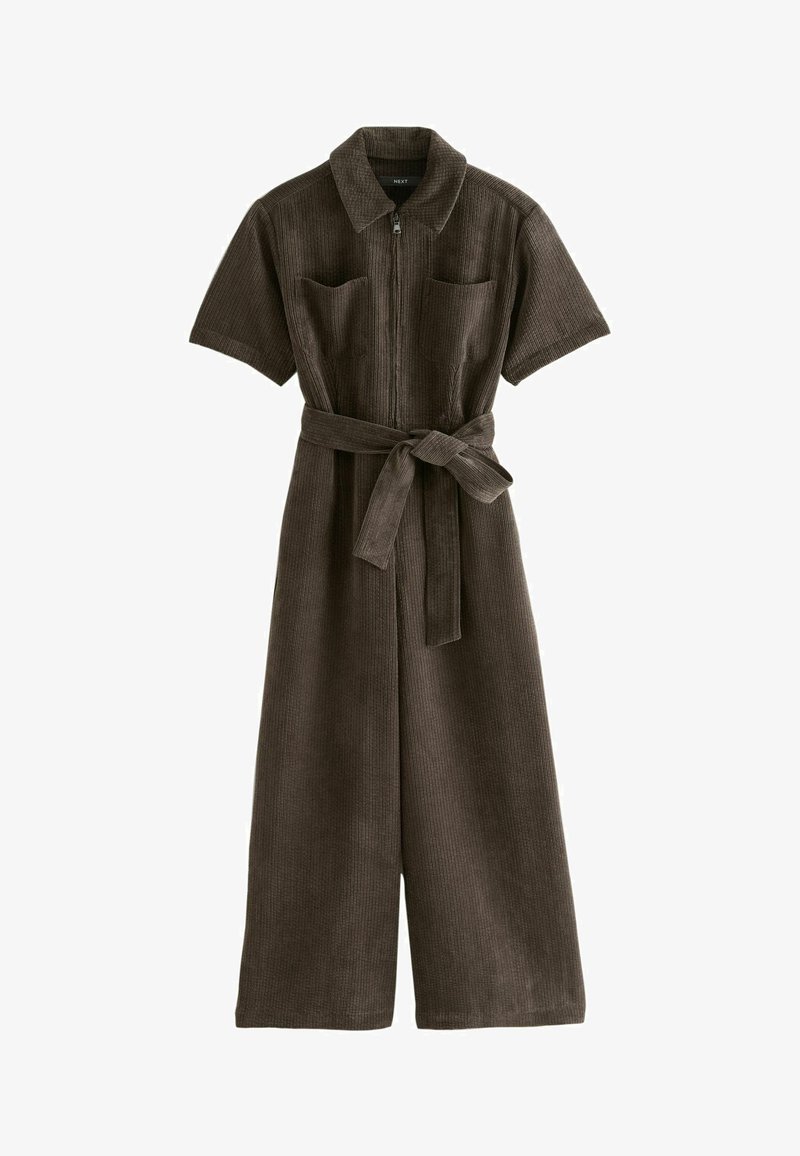 Salopette en velours côtelé marron avec des manches courtes, fermeture éclair sur le devant, deux poches poitrine et une ceinture nouée à la taille. Équipée de jambes larges et d'un tissu texturé.