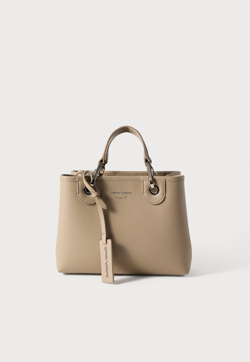Μπεζ δερμάτινη τσάντα με υφή, δύο επάνω λαβές, εξαρτήματα σε ασημί απόχρωση και αποσπώμενη ετικέτα με το όνομα της μάρκας.