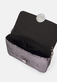Clutch bag in tessuto argentato con paillettes, fodera nera, elementi in argento e chiusura a scatto. L'interno presenta una piccola tasca.