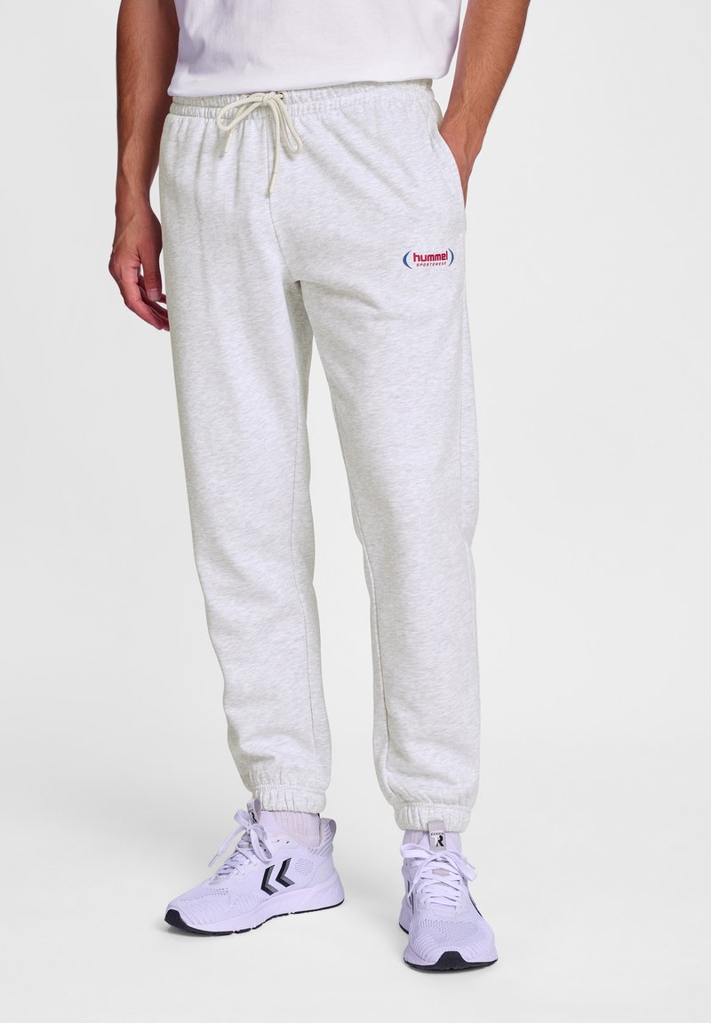 Helle graue Jogginghose aus weichem Stoff, mit einem elastischen Bund und Kordelzug, sowie einem kleinen roten Logo auf dem linken Oberschenkel.