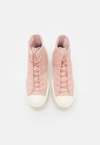 Höga sneakers i mjuk rosa mocka med matchande snören, vit gummitå och texturerad tunga. Ren design, utan utsmyckningar.