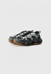 Lightweight athletic shoes in black and gray with a textured upper, rubber sole, and patterned accents. Features a lace-up design and cushioning.
