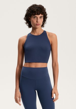 Marineblauer Sport-BH, ärmellos mit hohem Kragen, aus glattem Stoff gefertigt. Passende hochgeschnittene Leggings verfügen über ein nahtloses Design.