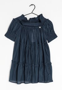 Abito blu navy a maniche corte con volant sovrapposti e dettagli smock appeso a una gruccia nera su sfondo bianco.