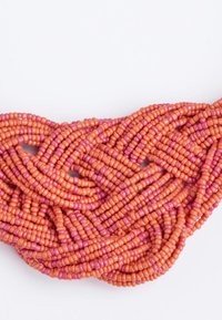 Kralenketting met verwoven strengen in matte oranje en roze kleuren, met kleine cilindrische kralen en een gladde textuur.