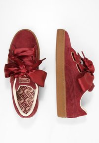 Baskets en velours côtelé rouge avec de grands nœuds en satin, semelle en caoutchouc et logo embossé sur la languette. Dotées d'une semelle intérieure à motif et d'accents texturés sur les côtés.