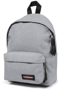 Grå tygryggsäck med rundad topp, framfickan med dragkedja, justerbara remmar och strukturerad yta. Har Eastpak-logotypen på framsidan.