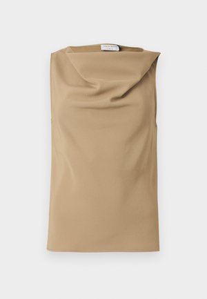 Beige ermeløs topp med løs, drapert halslinning og liten synlig etikett ved kragen mot hvit bakgrunn.