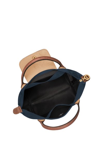 Marineblaue Tragetasche mit braunen Ledergriffen und Akzenten. Baumwollaußenmaterial, ein Fächer, Druckknopfverschluss, schwarzes Innenfutter.