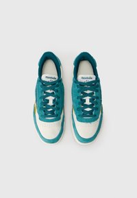 Ζευγάρι αθλητικών παπουτσιών Reebok σε τιρκουάζ και λευκό με κορδόνια, προσεγγισμένο από πάνω πάνω σε λευκό φόντο.