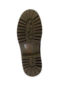 Rubberen zool van schoenen met diepe profielen, cirkelvormige patronen en kruisvormige accenten. Lichtbruine kleur met een getextureerd oppervlak voor grip.
