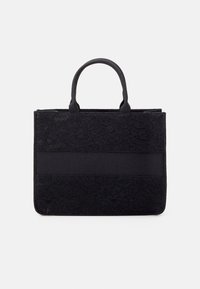 Borsa tote in pizzo nero con un design strutturato, dotata di due manici superiori, fondo piatto e una fascia di tessuto liscio al centro.