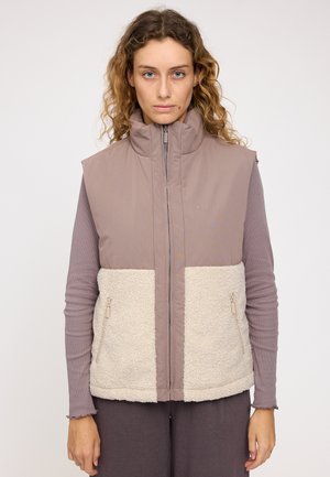 Fleece-lined sleeveless vest in taupe and cream, featuring a high collar, zip closure, and two side pockets. Textured fabric contrast.