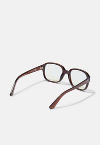 Bruine semi-rimless brillen met een rechthoekige vorm, heldere glazen en een glanzende afwerking. Kenmerkt gebogen frame met subtiele metalen accenten.
