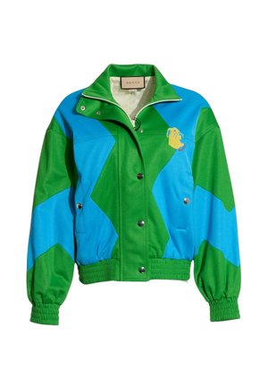 Chaqueta Gucci con bloques de color verde y azul, con botones a presión, puños y bajo elásticos, y una pequeña cara de animal amarilla bordada en el pecho.