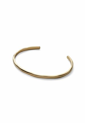 Tenký, mierne nepravidelný otvorený náramok v tvare manžety zo zlata s hladkým lesklým povrchom na bielom pozadí.