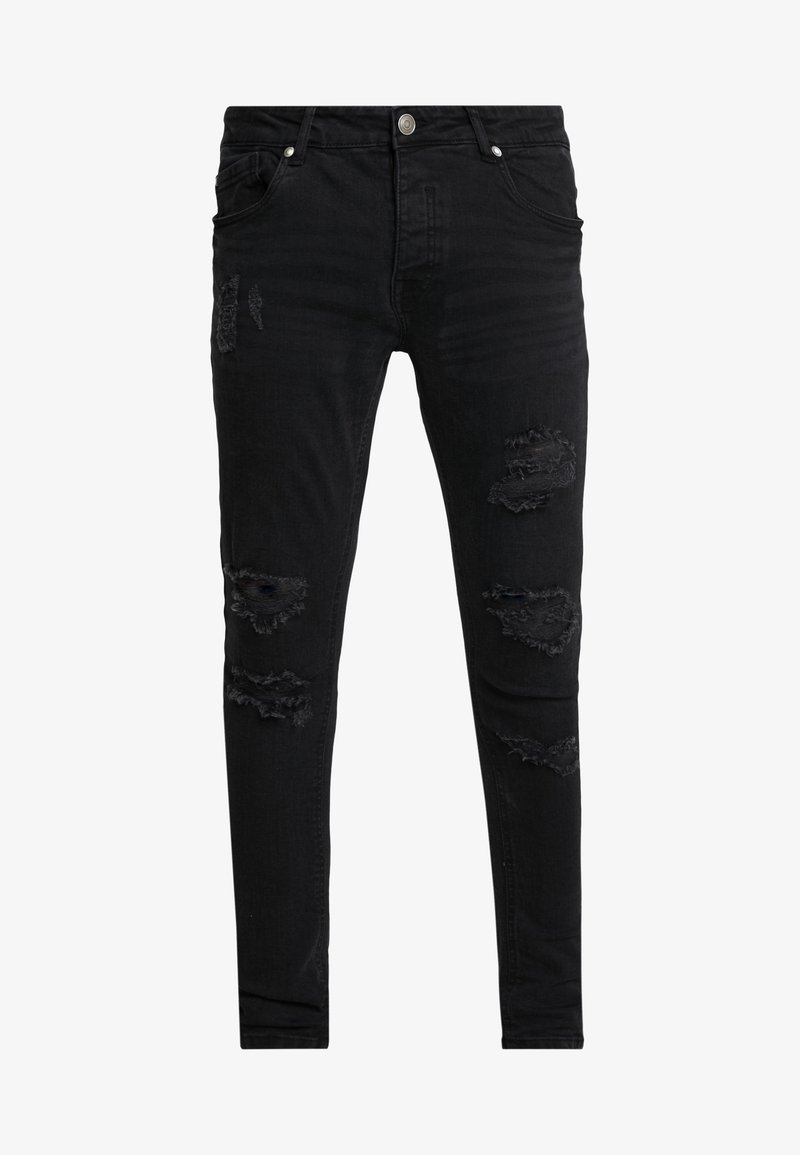 Pantalones vaqueros skinny negros hechos de denim, con acentos desgastados que presentan varios desgarros y bordes deshilachados. Bolsillos frontales y cierre de botón.