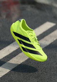 Lime green athletic shoe with black stripes, sleek design, lightweight mesh material, and minimalistic features.