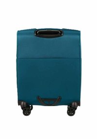 Valigia a guscio morbido di colore turchese con superficie texture, maniglia superiore e quattro ruote nere per la mobilità. Include una tasca di stoccaggio sul retro.