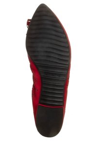Chaussure rouge avec un dessus en daim texturé, présentant des motifs floraux découpés au laser. La semelle en caoutchouc noir a un design strié pour une meilleure adhérence.
