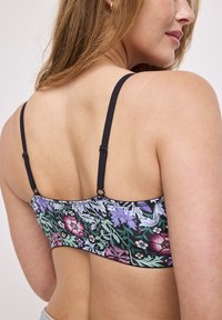 Blommönstrad bralette i svart med flerfärgade mönster. Mjuk tyg, justerbara svarta band och en slät baksida. Ingen bygel.