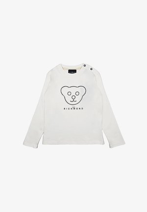 Una camicia bianca di cotone a maniche lunghe con una grafica di un orso nero e il nome del marchio al centro, con dettagli a bottoni a pressione sulle spalle.