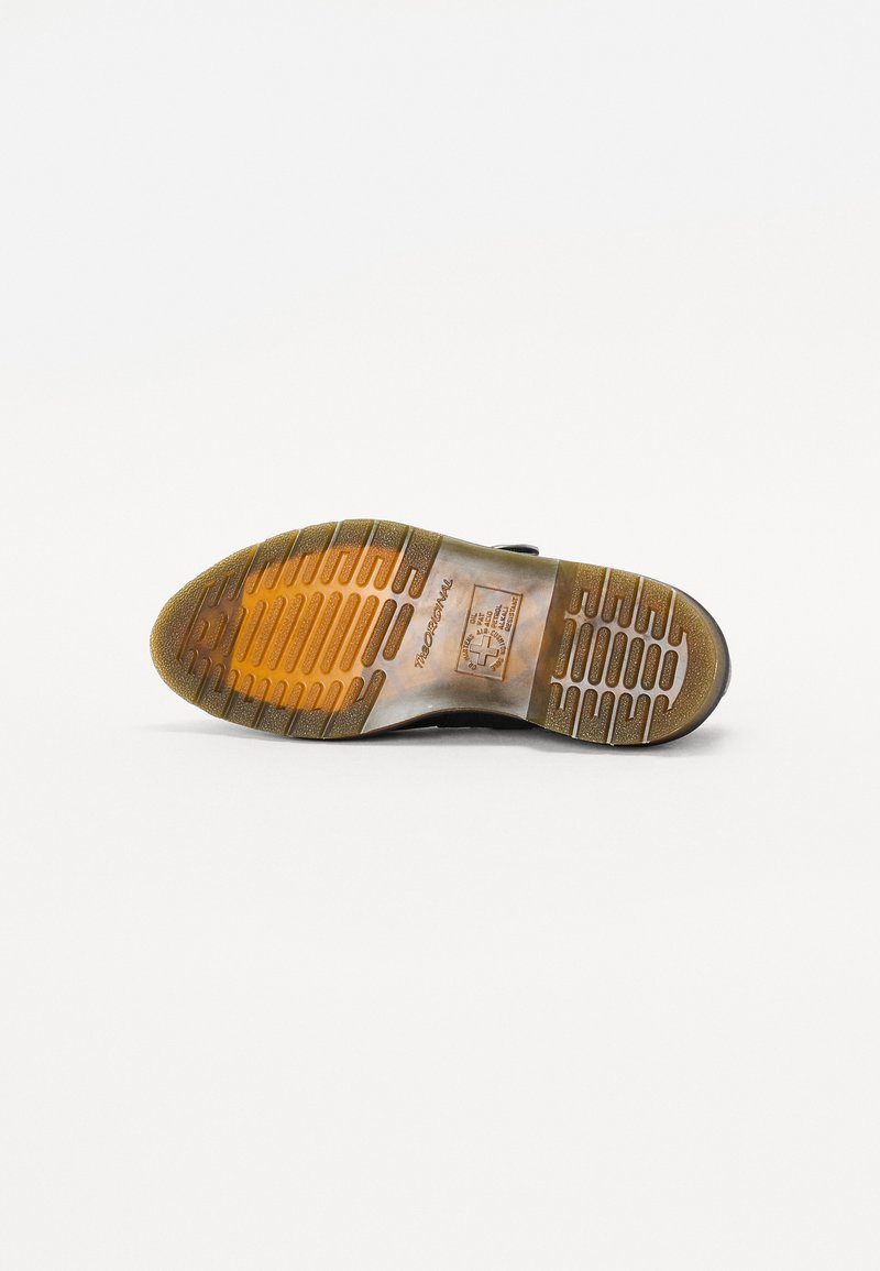 Black rubber shoe sole with textured tread pattern and orange highlights. Features a smooth, flexible surface and prominent brand logo.