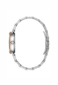 Montre en métal argent et doré avec un cadran rond, bracelet à maillons, accents texturés et finition polie, vue de côté.