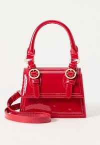 Sac à main en cuir verni rouge avec un design structur�é, une anse ronde, des accents en métal doré et une bandoulière amovible.