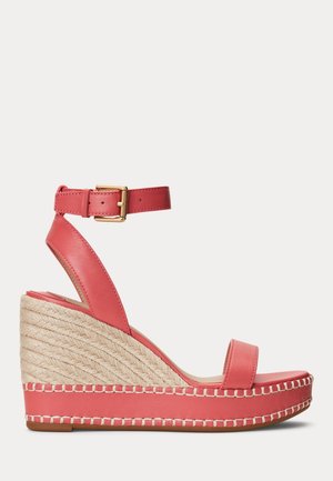 Sandales compensées en cuir corail avec une enveloppe en jute tressé, une bride à boucle dorée et une couture contrastante le long de la semelle.