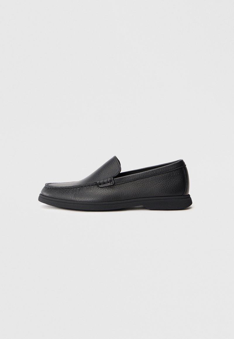 Mocassin noir en cuir à enfiler avec dessus texturé, talon bas et finition cousue le long de l’avant et des côtés.