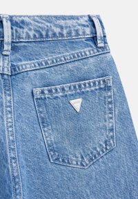Light blue denim jeans featuring a stitched rear pocket and a silver triangular logo accent. The fabric has a textured, faded finish.