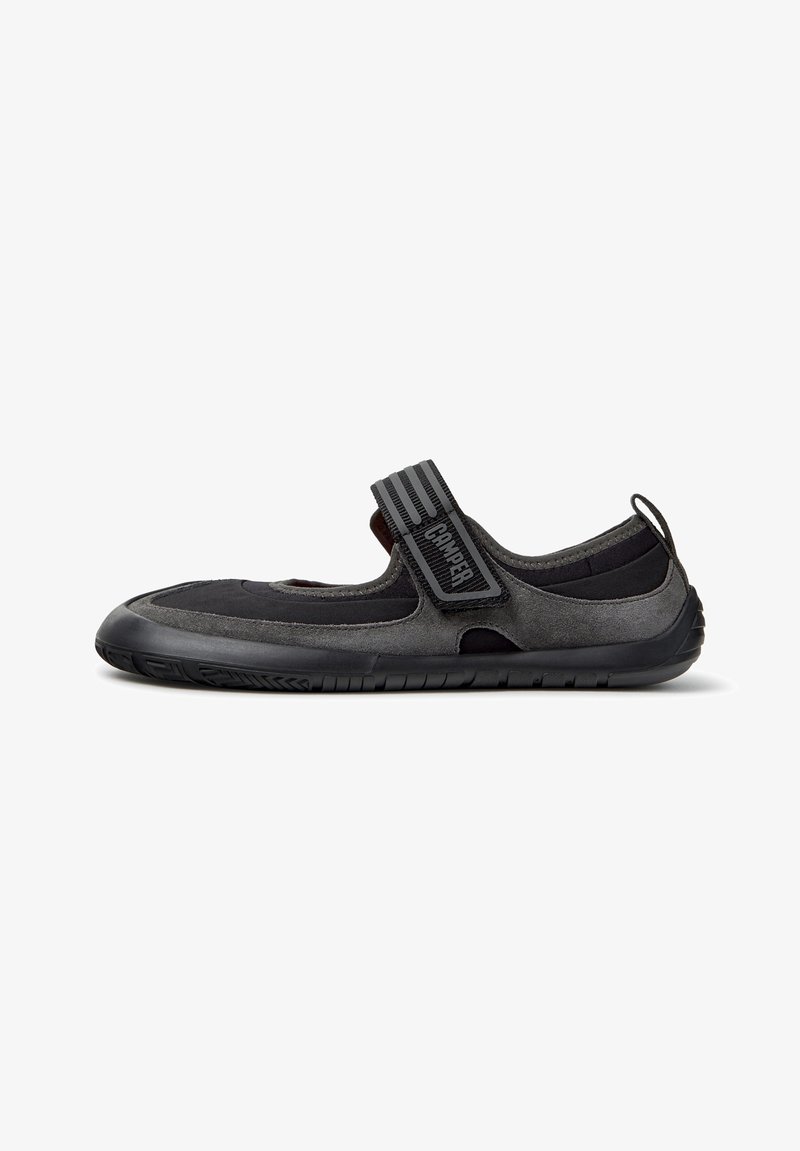 Chaussure d'eau noire et gris foncé avec une semelle en caoutchouc et une bride réglable portant l'inscription "Camper" sur le dessus.