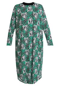 Lång klänning med ett mönster i grönt och svart zebramönster med vita tigerscarf, rund halsringning och långa ärmar. Mjuk, lätt tyg.