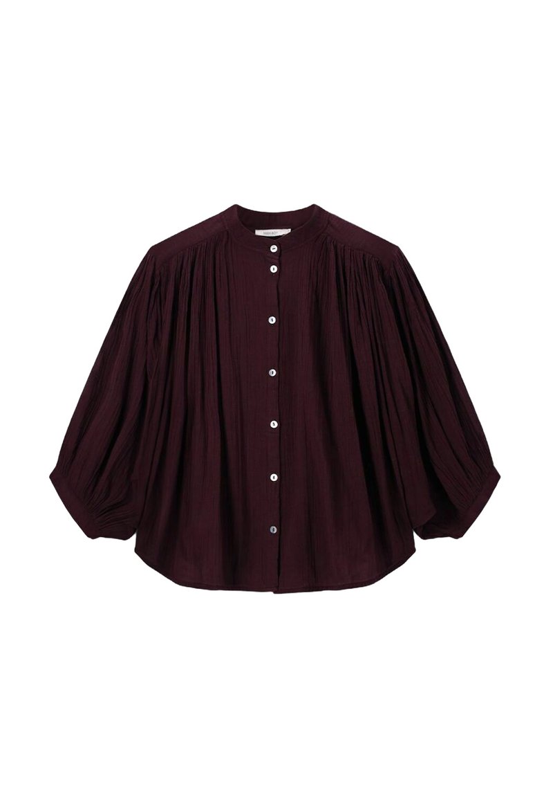Dark purple long-sleeve blouse with gathered fabric details, round neckline, and white front buttons, creating a loose, flowy silhouette.