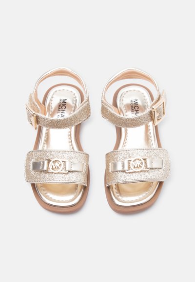 Παιδικά σανδάλια με χρυσό γκλίτερ, ρυθμιζόμενους ιμάντες στον αστράγαλο και λογότυπο Michael Kors στη μπροστινή λωρίδα, με επίπεδη σόλα.