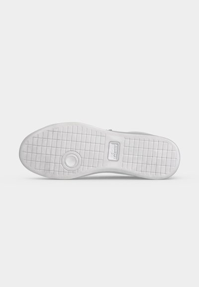 Подметка на бял обувка Lacoste с мрежест модел и кръгъл дизайн близо до петата на обикновен светъл фон.