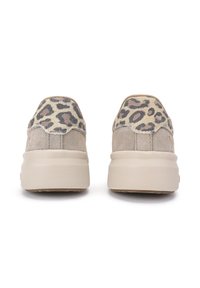 Zapatillas de ante beige con un acento de estampado de leopardo en tono marrón y tan en el talón, que cuentan con una suela gruesa de color crema.