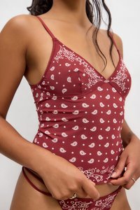 Burgundy patterned camisole with thin straps, featuring white paisley and floral designs. Soft, stretchy fabric with a fitted silhouette.
