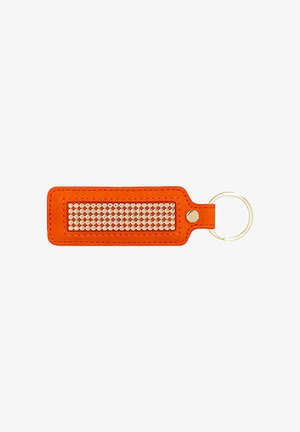 Oranje rechthoekige leren sleutelhanger met gouden ronde studs in het midden en metalen sleutelring bevestigd aan de rechterkant.