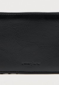 Μαύρο πορτοφόλι με υφή, κατασκευασμένο από συνθετικό δέρμα, με λεία επιφάνεια, ανάγλυφο λογότυπο και ραμμένα άκρα. Συμπαγές ορθογώνιο σχήμα.